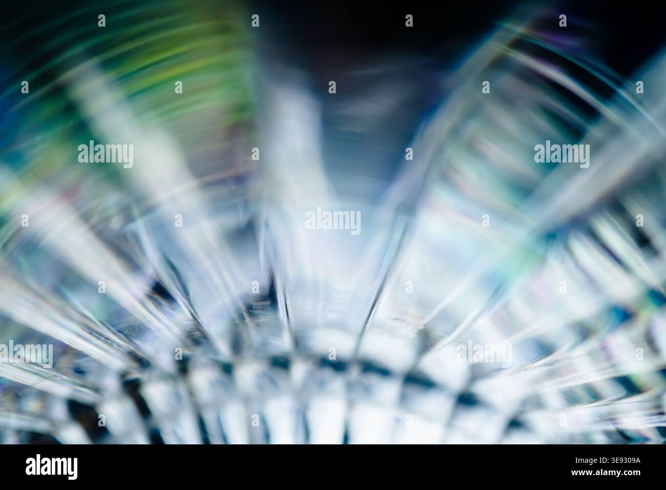 Abstract light refraction through glass creating circular turquoise and blue wave patterns Stock Photo