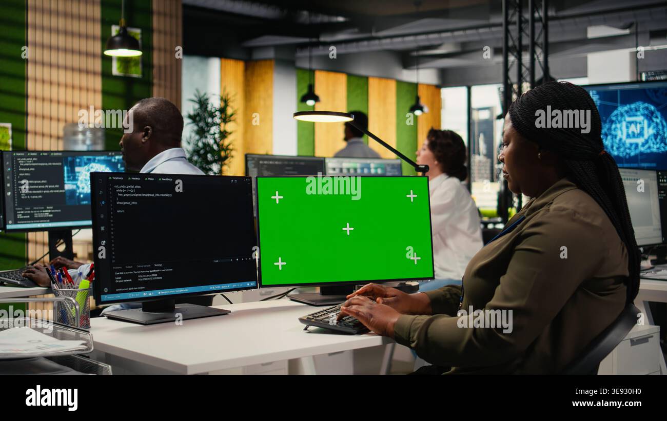 Green screen computer used by programmer in AI startup office to train predictive models for language processing tasks. IT expert uses deep learning technology on mockup PC, camera A Stock Photo