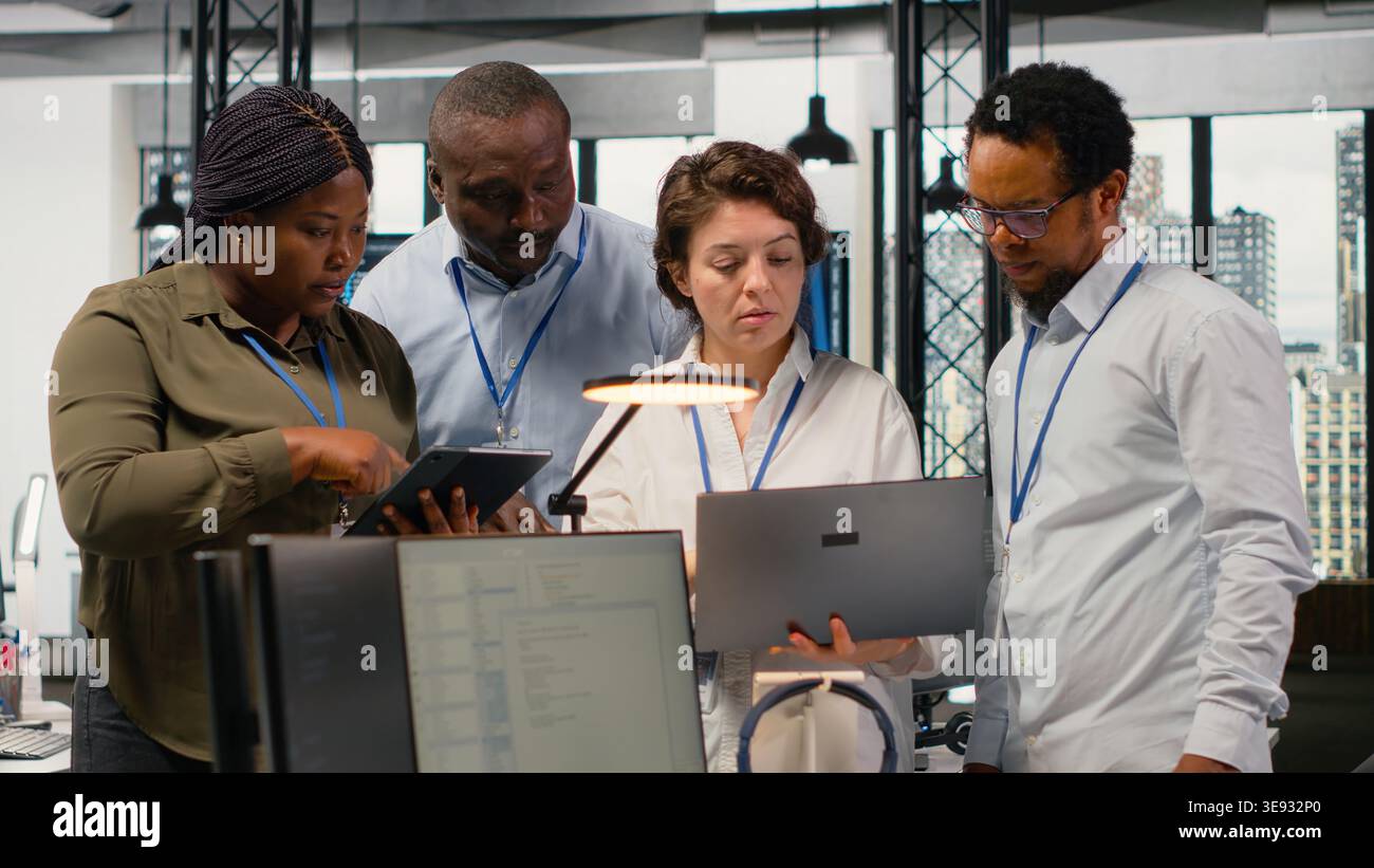 Portrait of smiling engineering team in office automating workflows using artificial intelligence tech. Happy coworkers refining deep learning computational models for faster processing, camera B Stock Photo