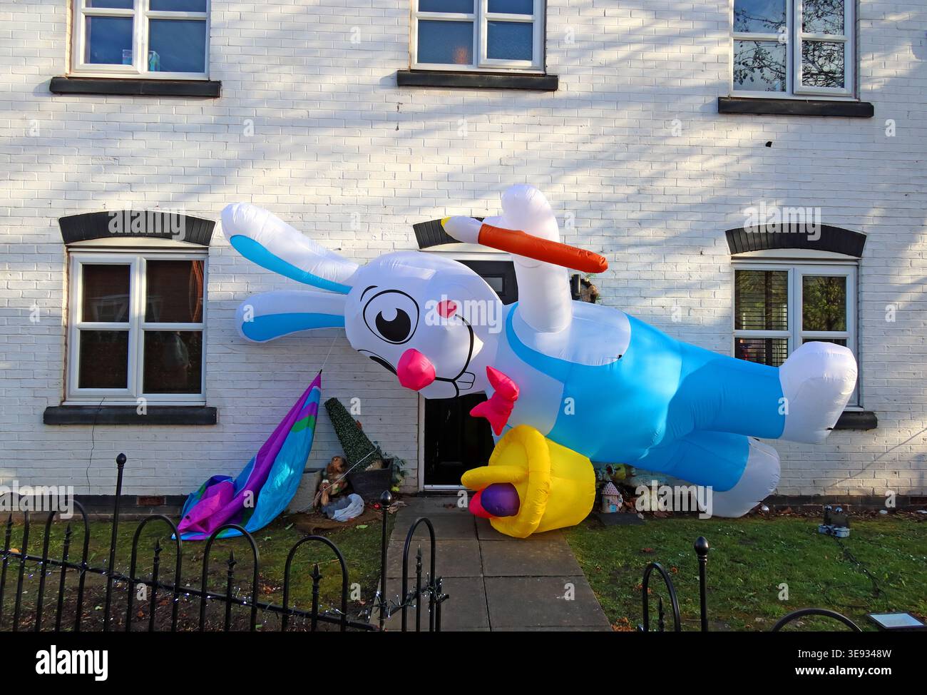 Giant inflatable Easter rabbit outside a house in Latchford, Warrington, adding colourful spring decoration to a front garden. Stock Photo