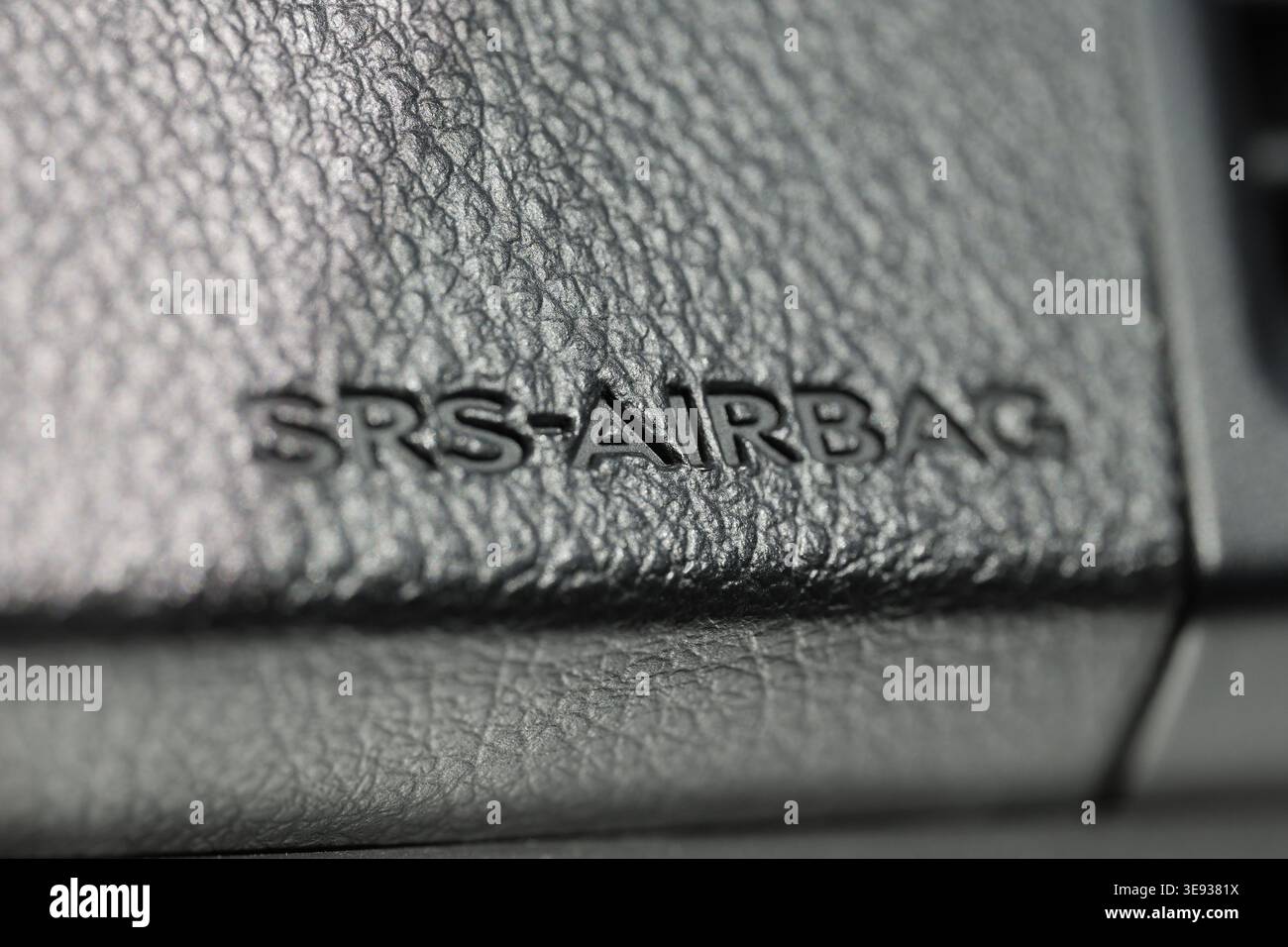 Macro detail of SRS Airbag embossed text on a black textured leather vehicle dashboard Stock Photo