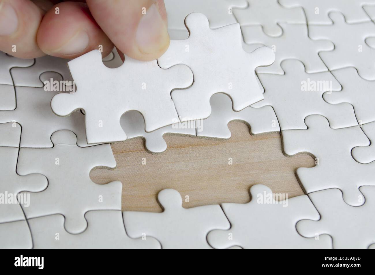 Hand placing missing jigsaw puzzle pieces. Solution concept Stock Photo
