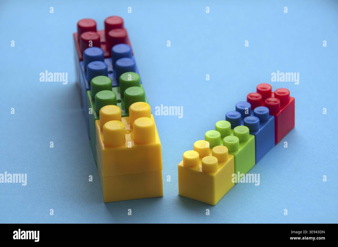 Plastic building blocks on blue background. Copy space Stock Photo
