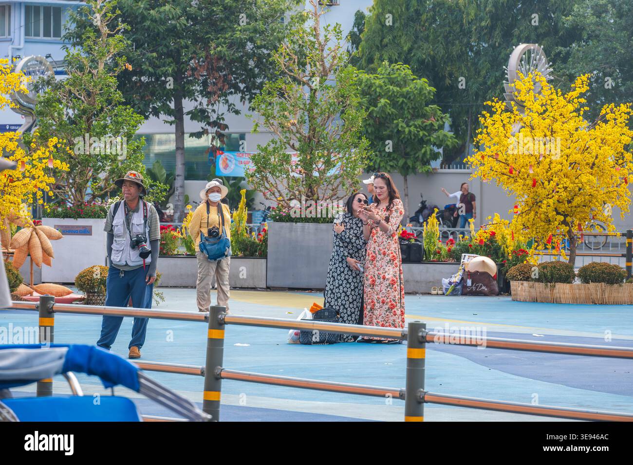 People Relaxing and Taking Photos in a Vibrant Urban Park Stock Photo