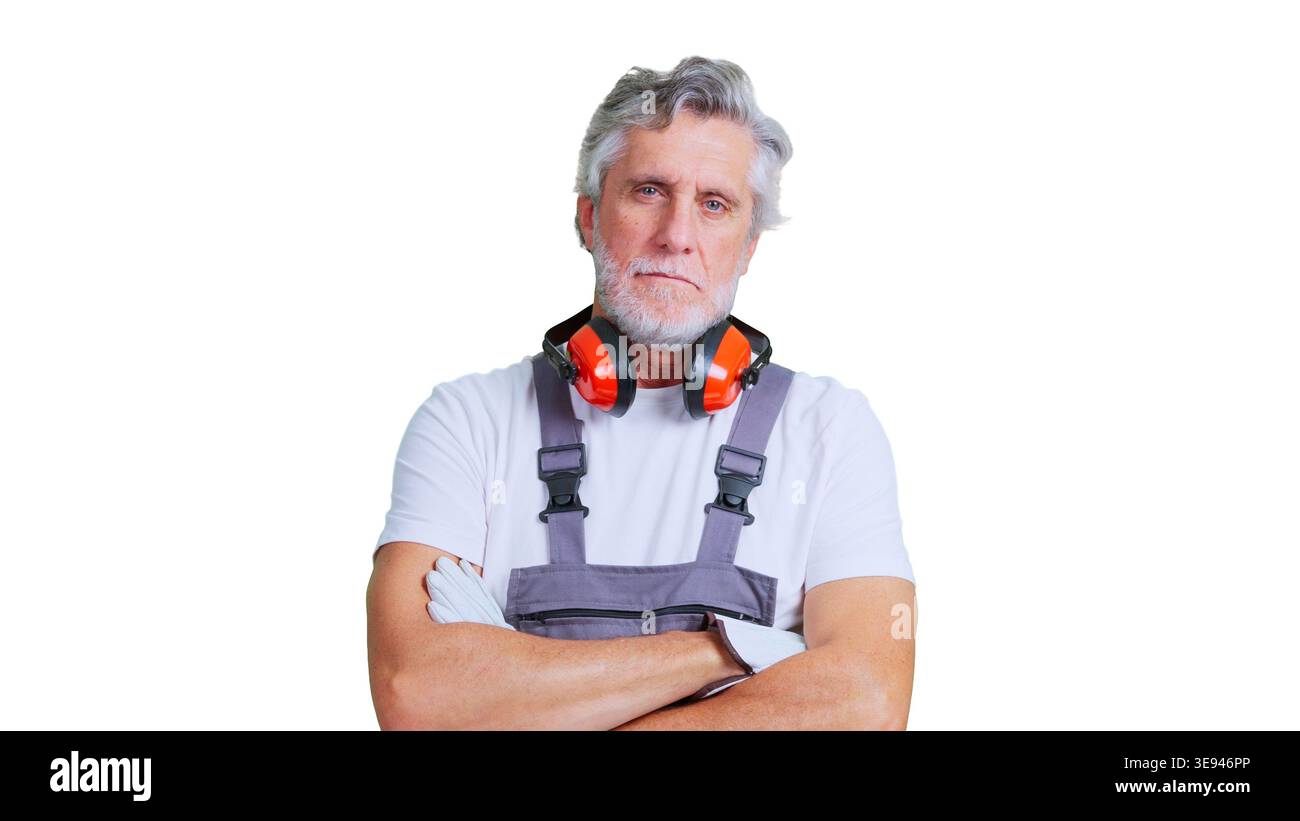 Senior construction worker standing with protective earmuffs Stock Photo