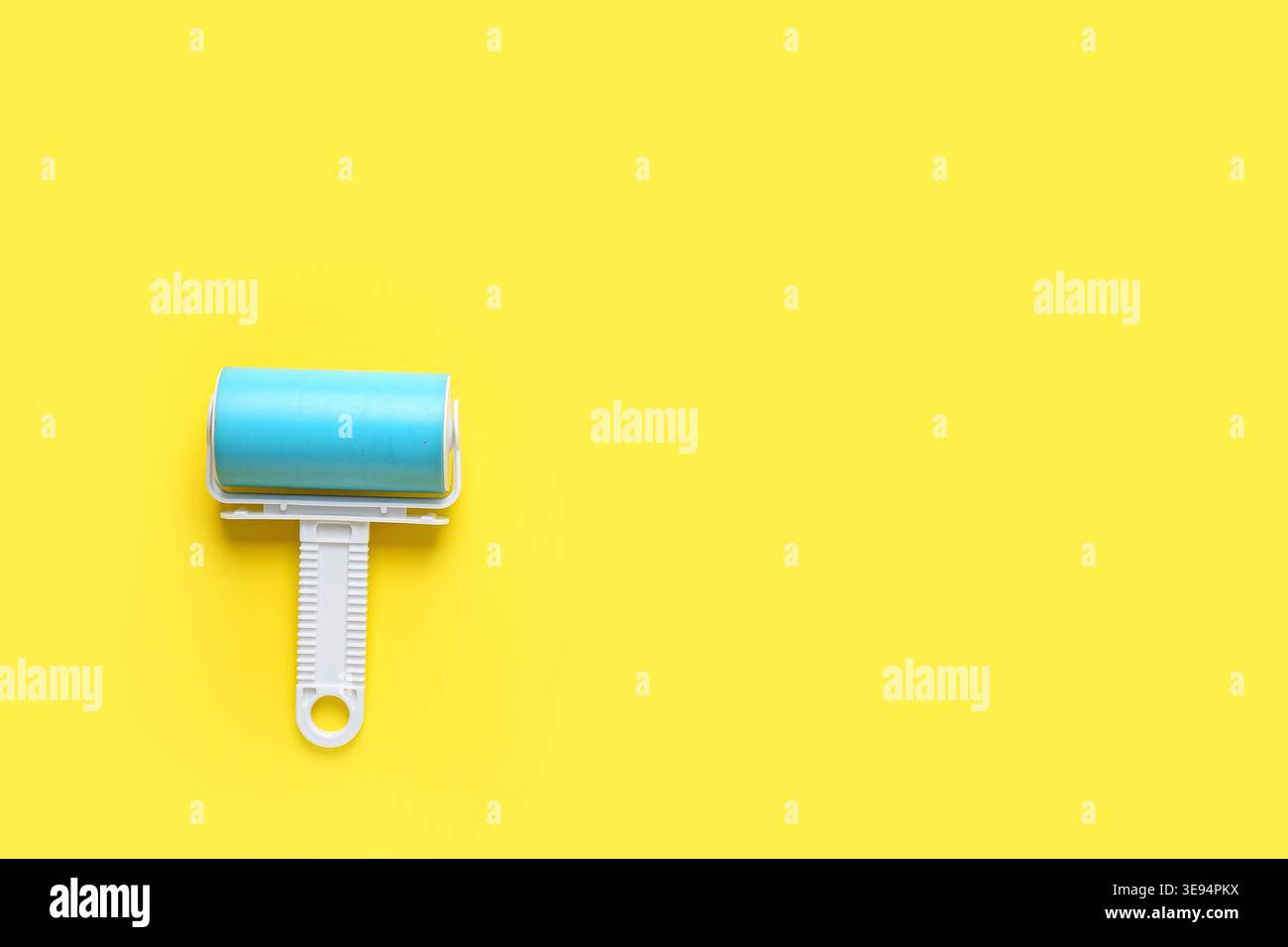 Lint roller on yellow background Stock Photo