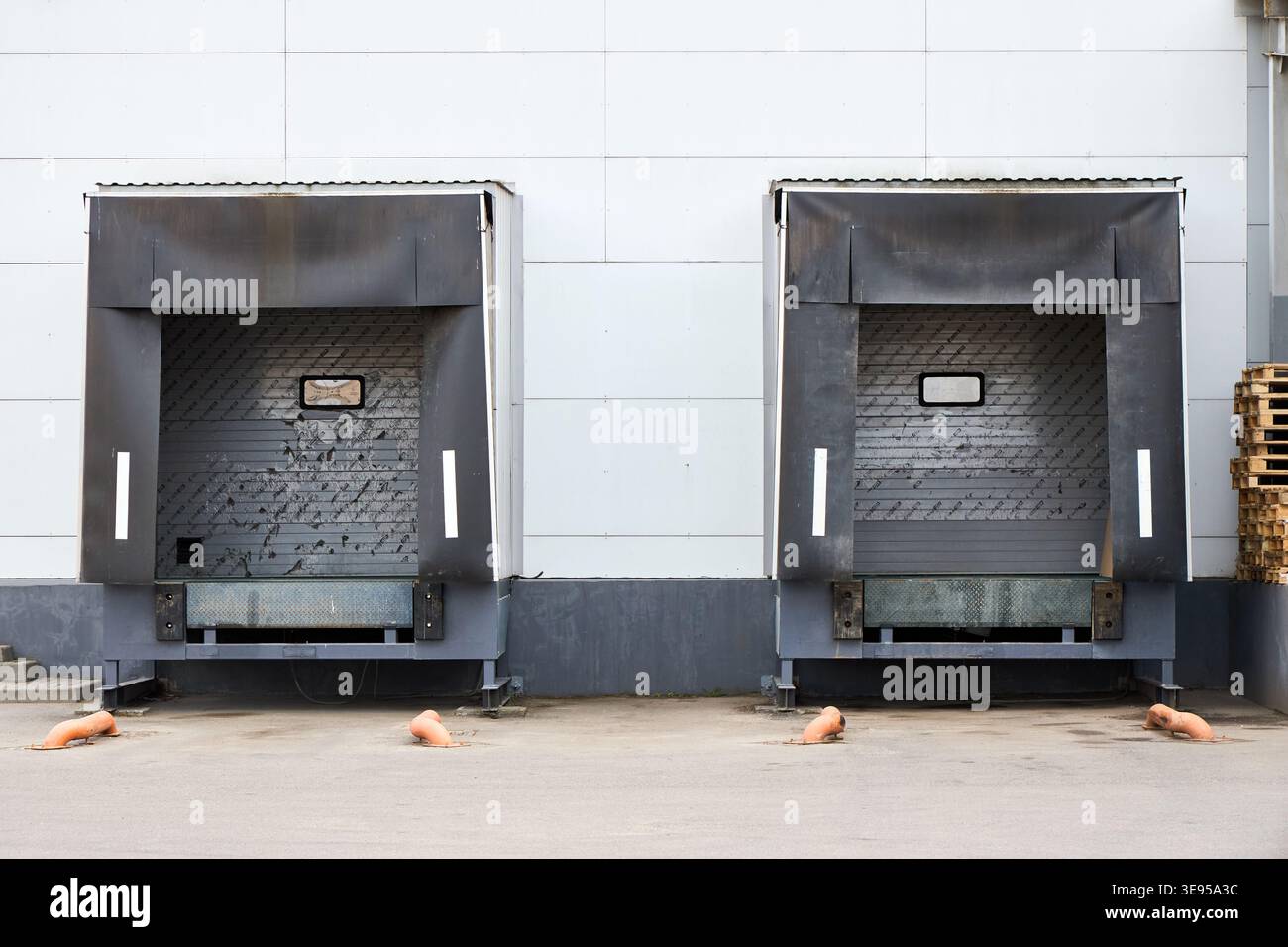 Loading dock or loading bay with bumpers, levelers, lift, dock seals or shelters, traffic lights. Loading bay is area of building where goods vehicles Stock Photo