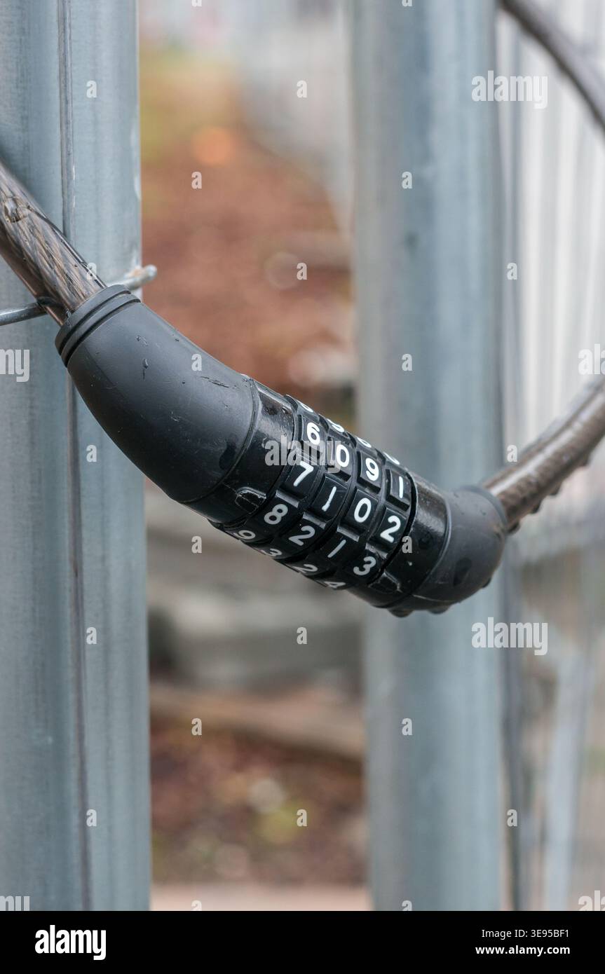 chain link fence with chain and key code padlock vertical Stock Photo