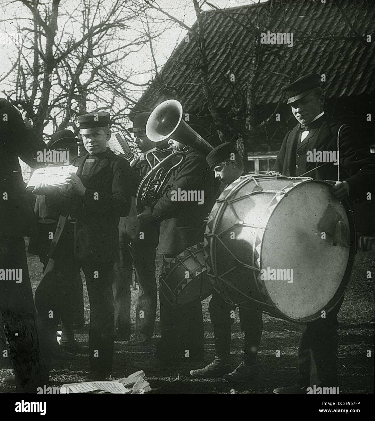 A musician with a large drum and another playing a horn at the ...