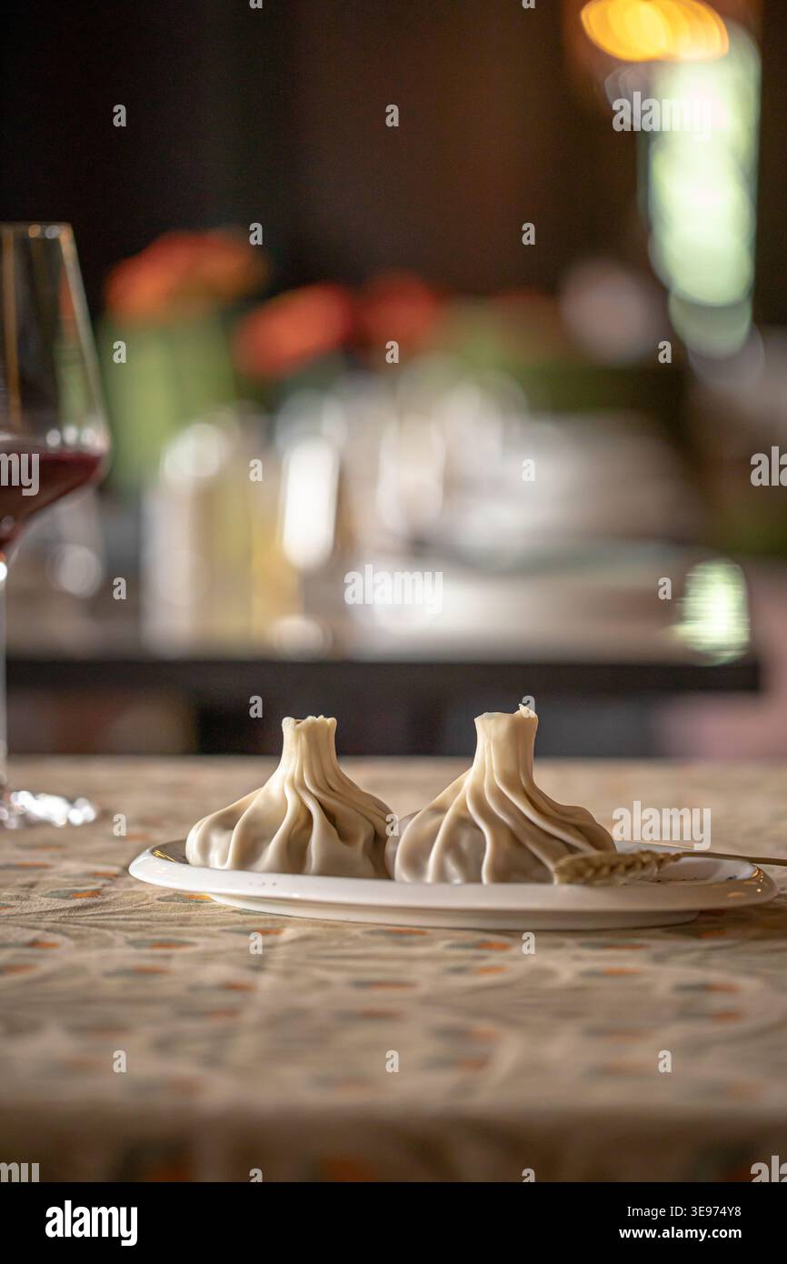 Khinkali dumplings with wine on restaurant table Stock Photo
