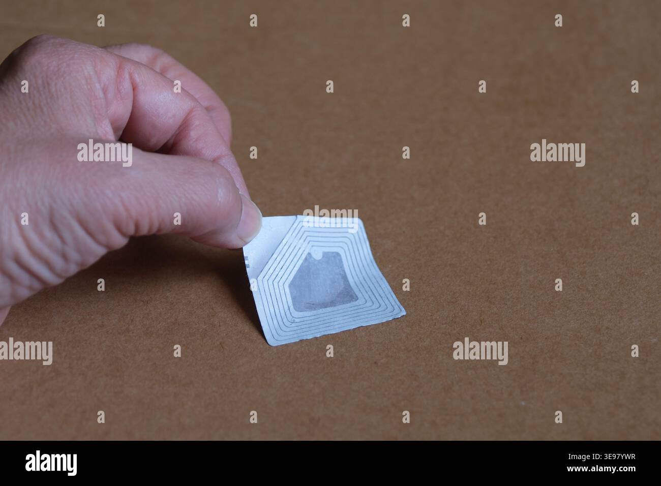 Hand sticking a rfid sticker on a box Stock Photo
