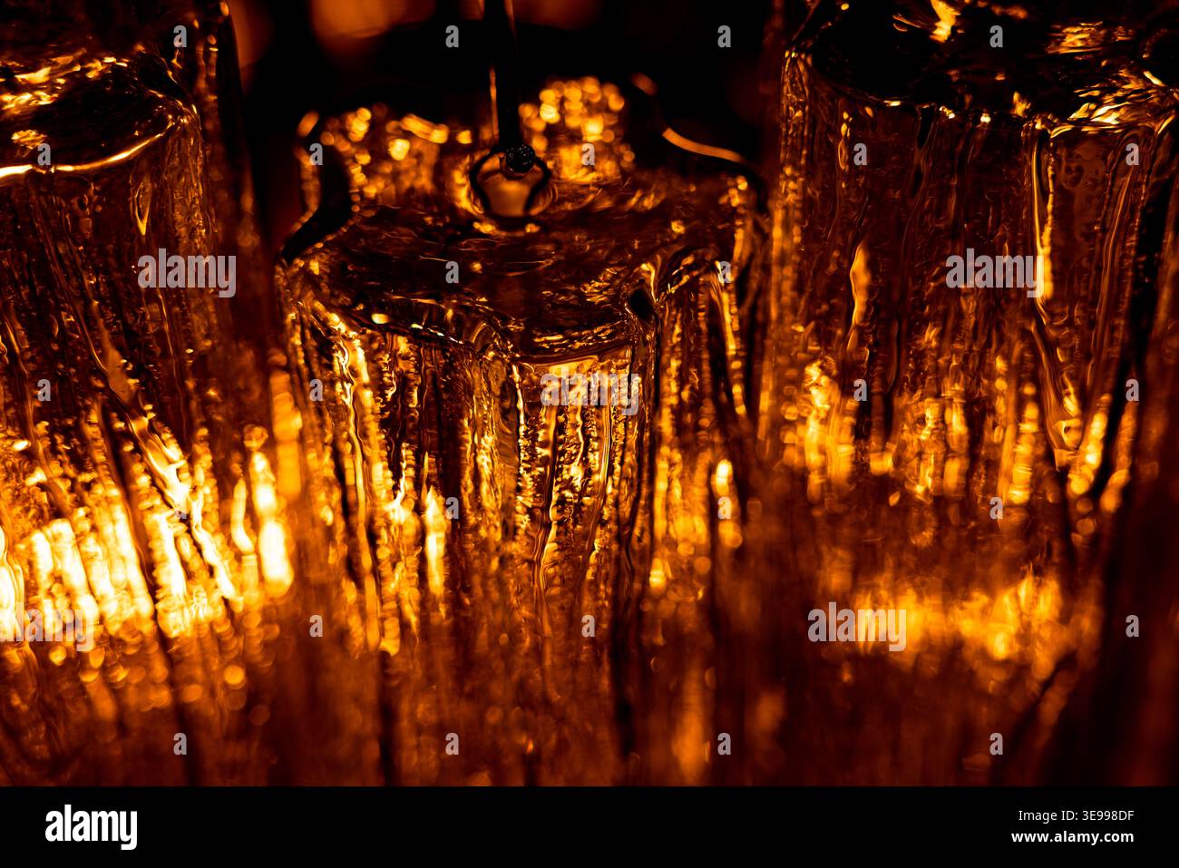 Abstract golden light through textured glass surface Stock Photo
