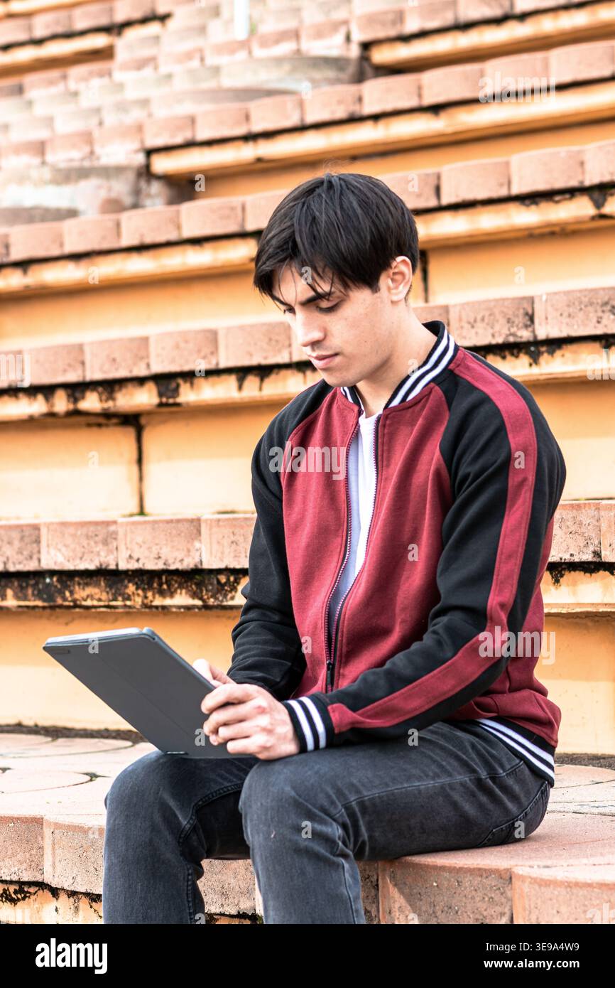 Young student learning outdoors using digital tablet Stock Photo