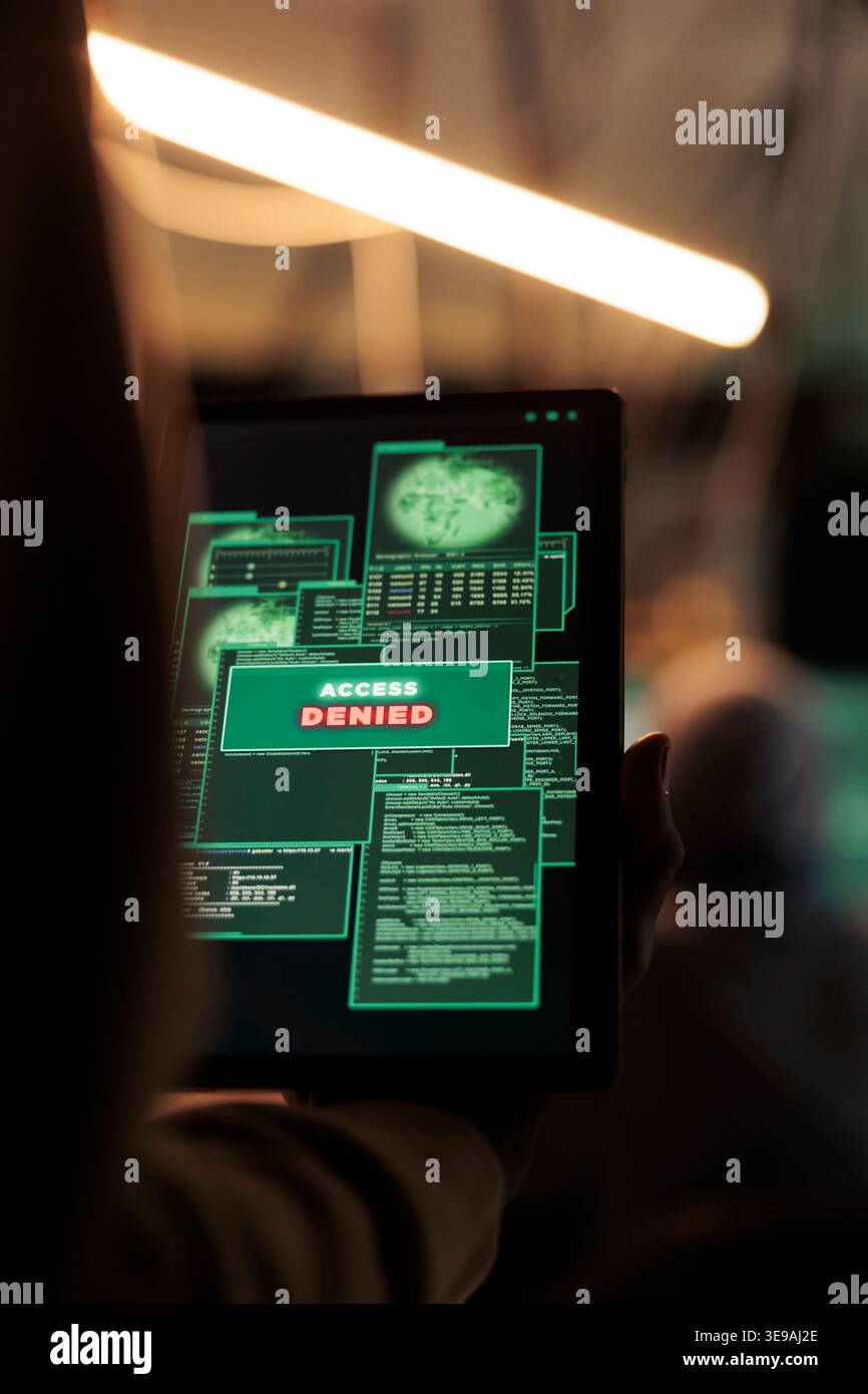 Access denied message on digital tablet, hacker failed database hacking, unsuccessful password cracking. Cybercrime, internet criminal using malicious software, stealing data at night time Stock Photo