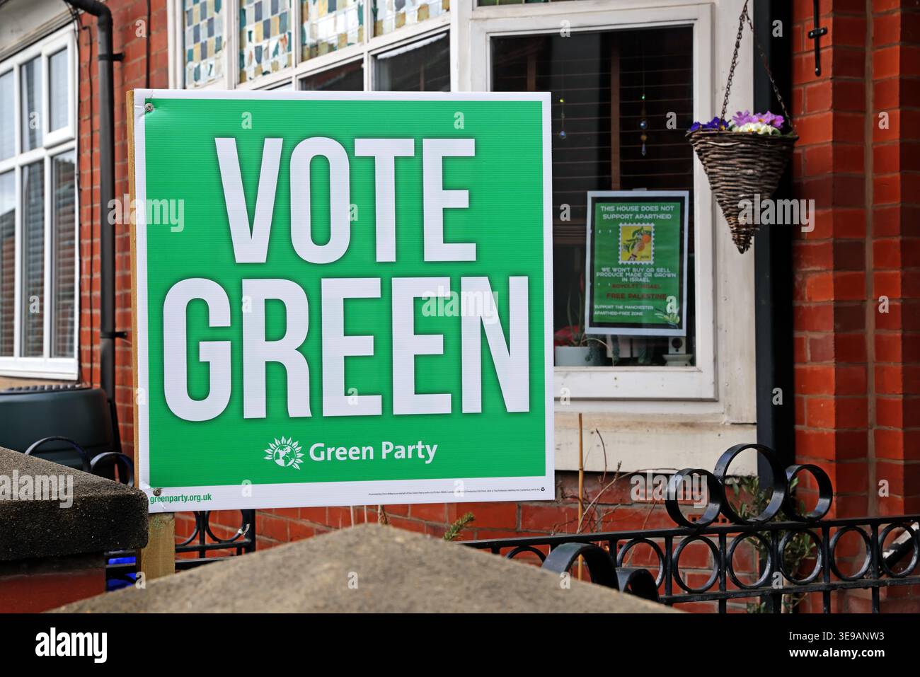Vote Green garden banner and Boycott Israel poster in suburban UK house window, grassroots political campaigning scene Stock Photo