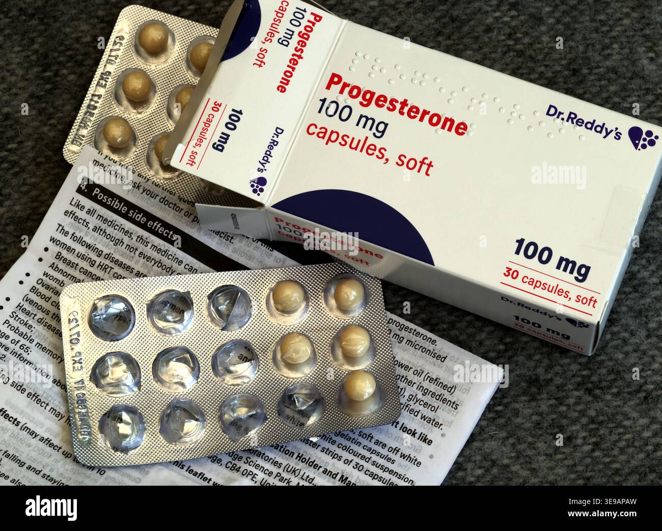 Close-up macro of Progesterone 100mg soft capsules, blister packs and Possible Side Effects leaflet for HRT medication Stock Photo