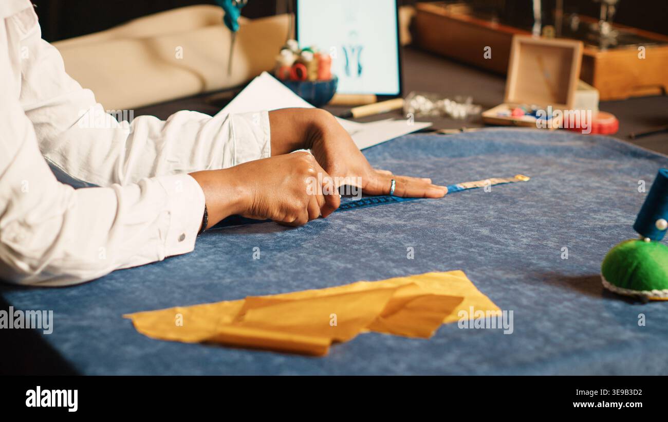 Young tailor using meter on fabric for custom made clothes collection, sewing industry. Female couturier doing measurements to make luxury design for clients. Handheld shot. Close up. Stock Photo