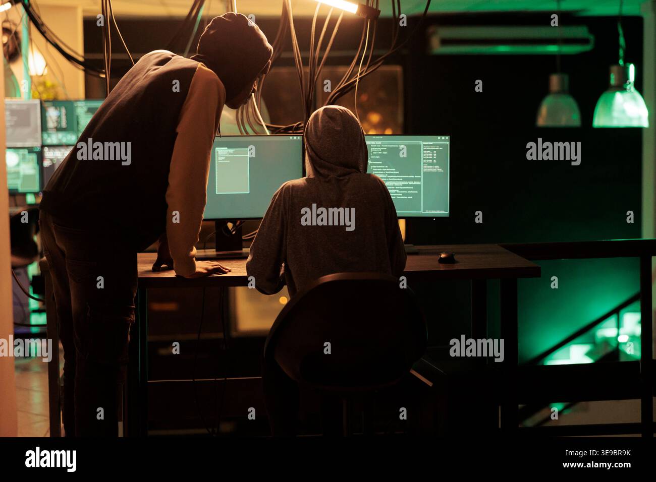 Hackers coding malicious software, cracking database password, online server illegal access, data breach. Cybercrime, internet thieves hacking computer network system at night time Stock Photo