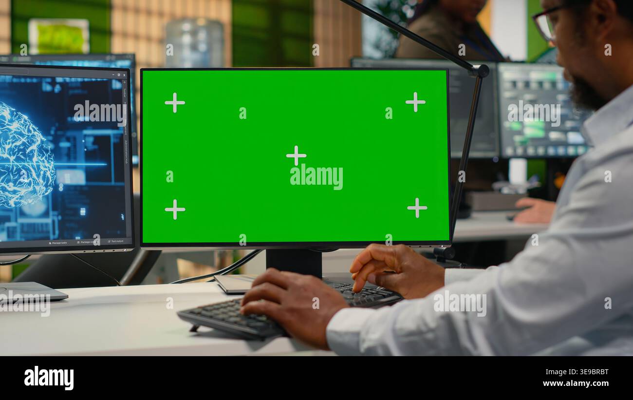 Green screen mockup PC used by data scientist in office automating workflows with artificial intelligence. IT worker refines deep learning models on chroma key computer for faster processing, camera B Stock Photo