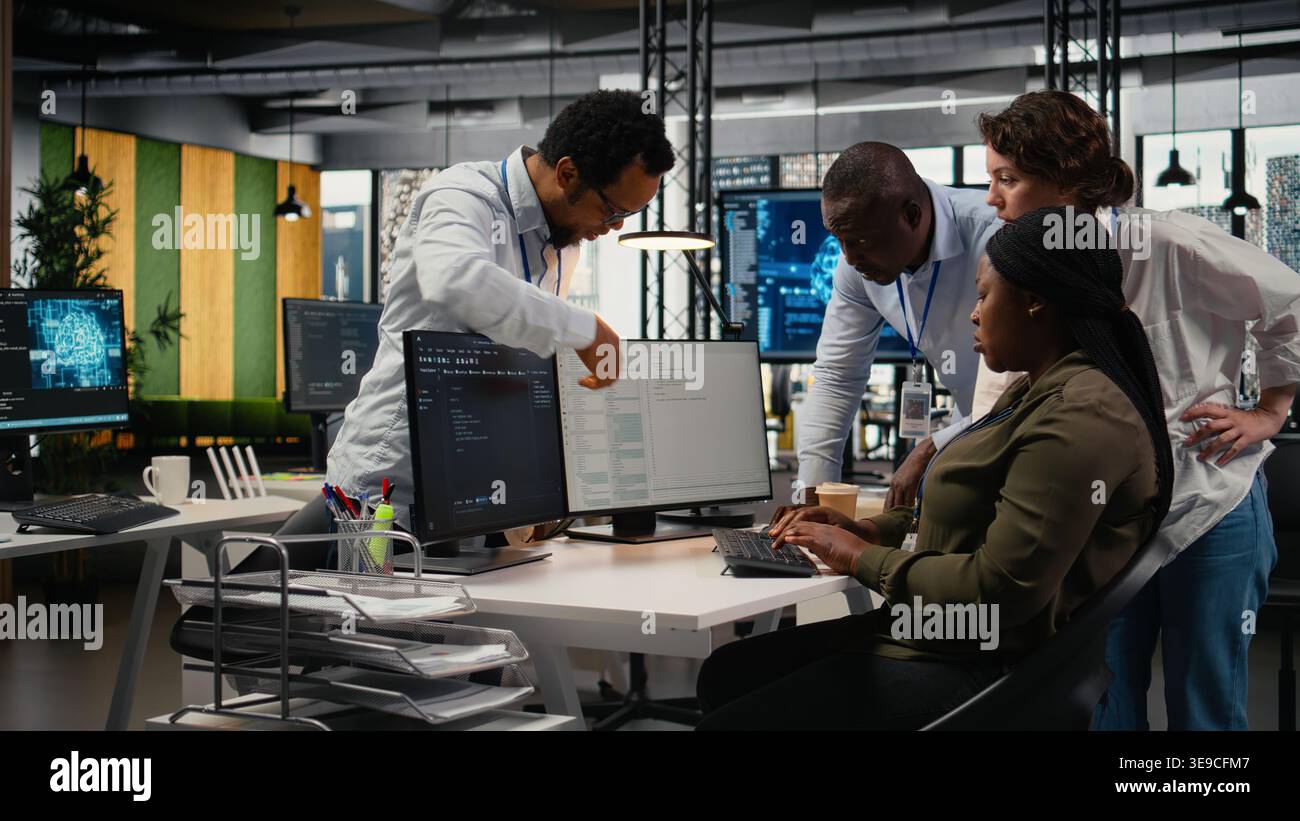 Team of technicians in office working together, automating workflows using AI. IT specialists collaborating to refine machine learning computational models for faster processing, camera A Stock Photo