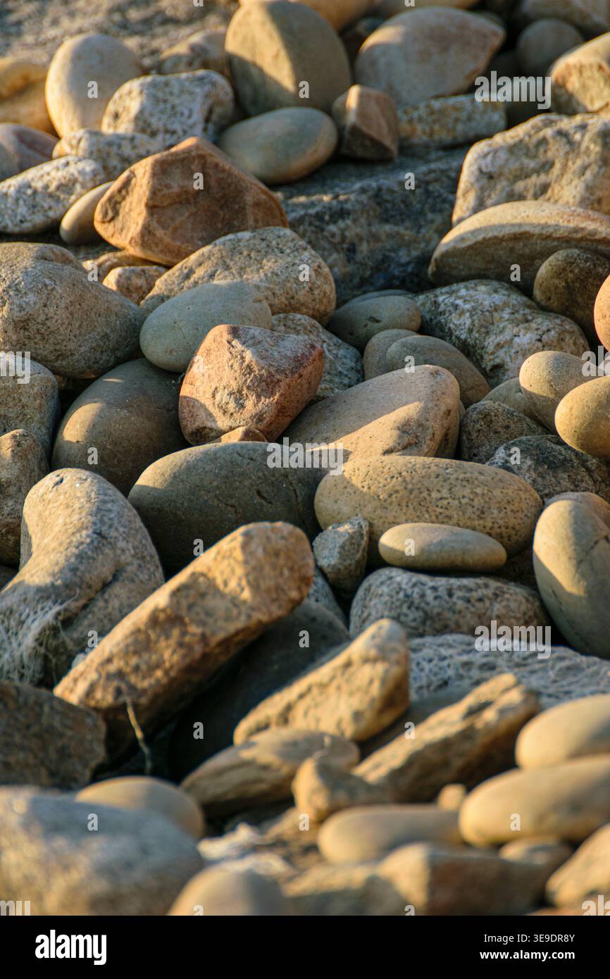 Vertical close up of smooth natural pebbles lying on a beach Stock Photo