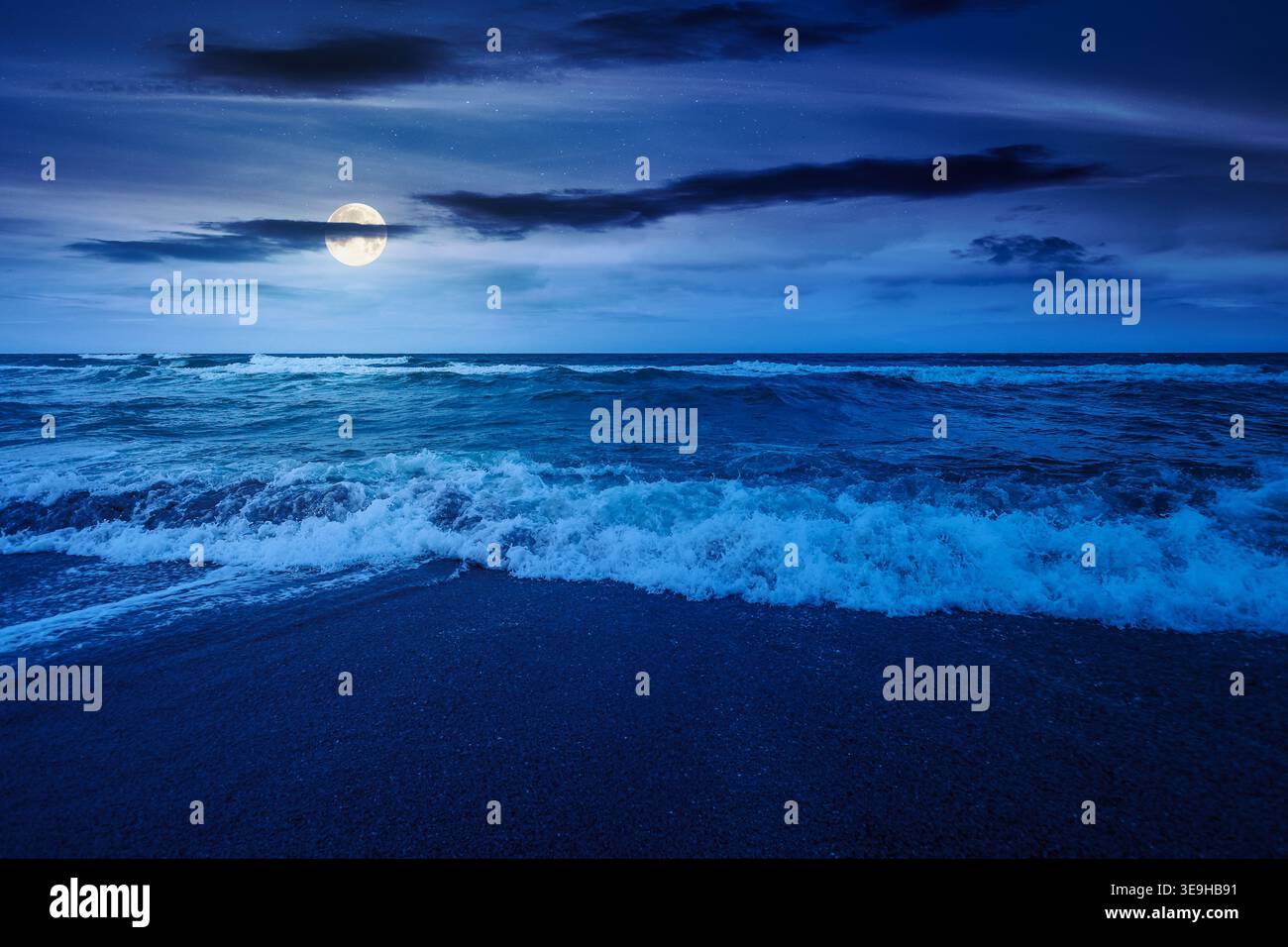 storm on the sandy beach at night. wonderful sea view with cloudy sky. full moon over salt water and crashing waves. mysterious view of bulgaria beach Stock Photo