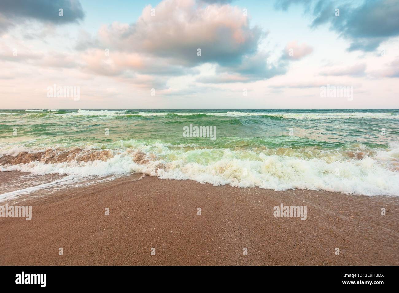 storm on the sandy beach in the afternoon. dramatic sea view with cloudy sky. salt water and crashing waves. view of bulgaria beach in summer. wind we Stock Photo
