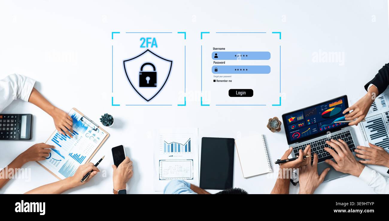 A team collaborates on cybersecurity solutions featuring two-factor authentication, showcasing technology tools like laptops and notebooks for data Stock Photo