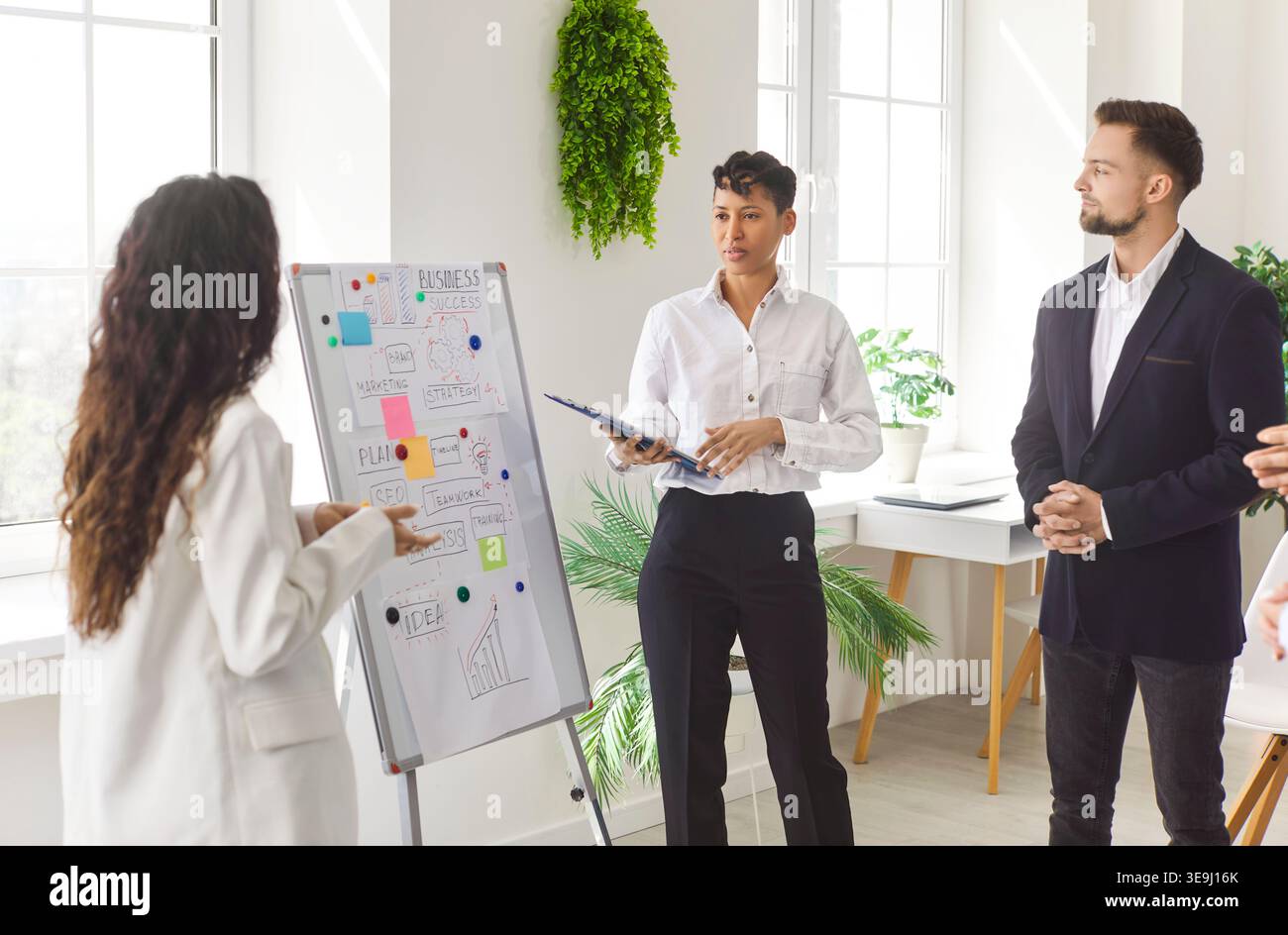 Businesswoman Leading Presentation In Office Meeting Stock Photo