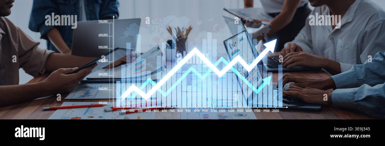 A dynamic office scene showcasing a diverse team collaborating over digital devices, with an analytics graph illustrating trends and growth for Stock Photo