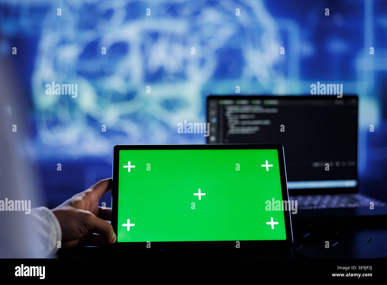 Admin writes code on green screen tablet to visualize artificial intelligence neural networks using augmented reality. High tech workspace supervisor runs AI script on chrome key device Stock Photo