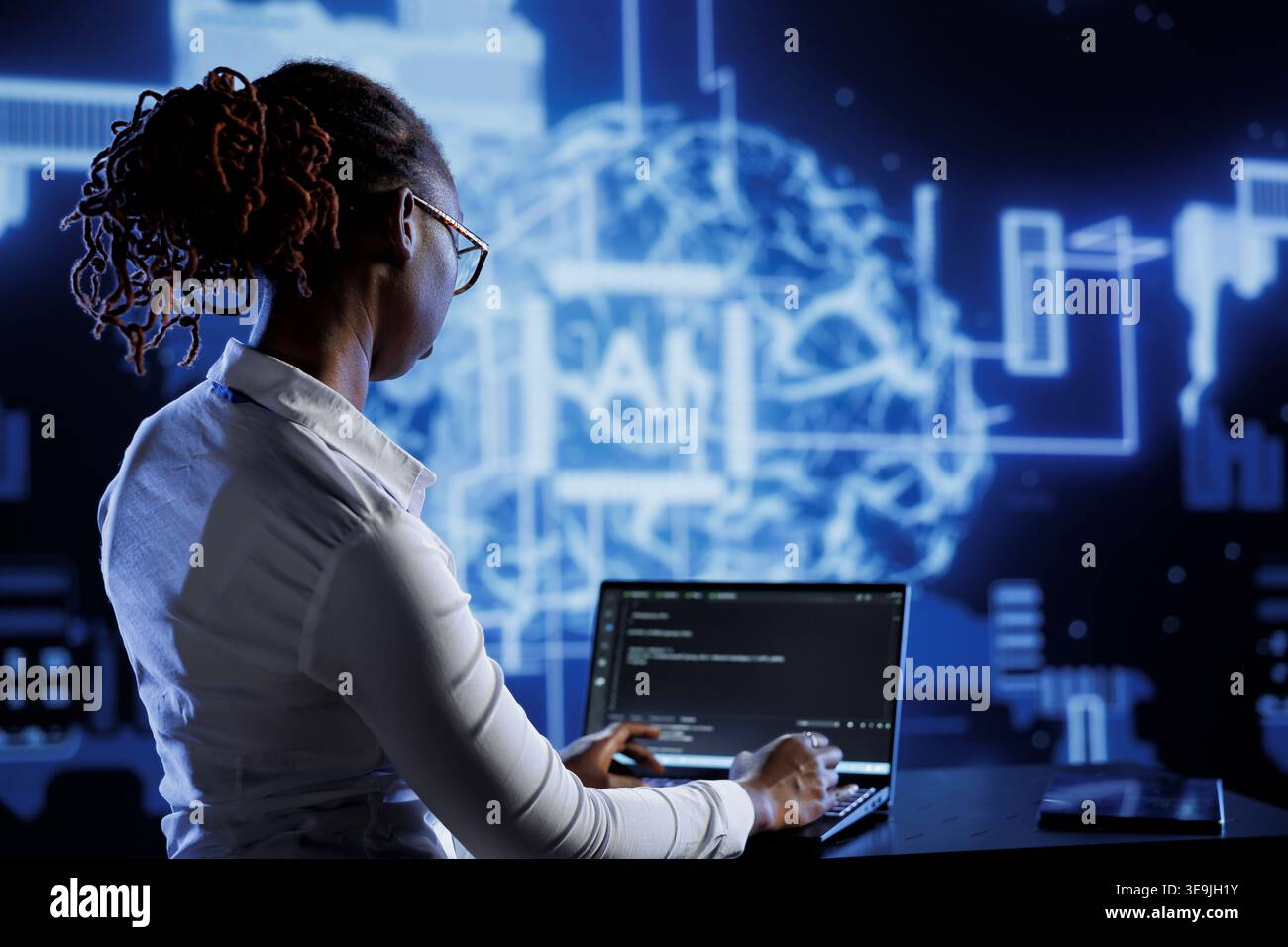 African american engineer updating AI systems, writing intricate binary code scripts on laptop. Tech support using programming to upgrade artificial intelligence simulation model Stock Photo