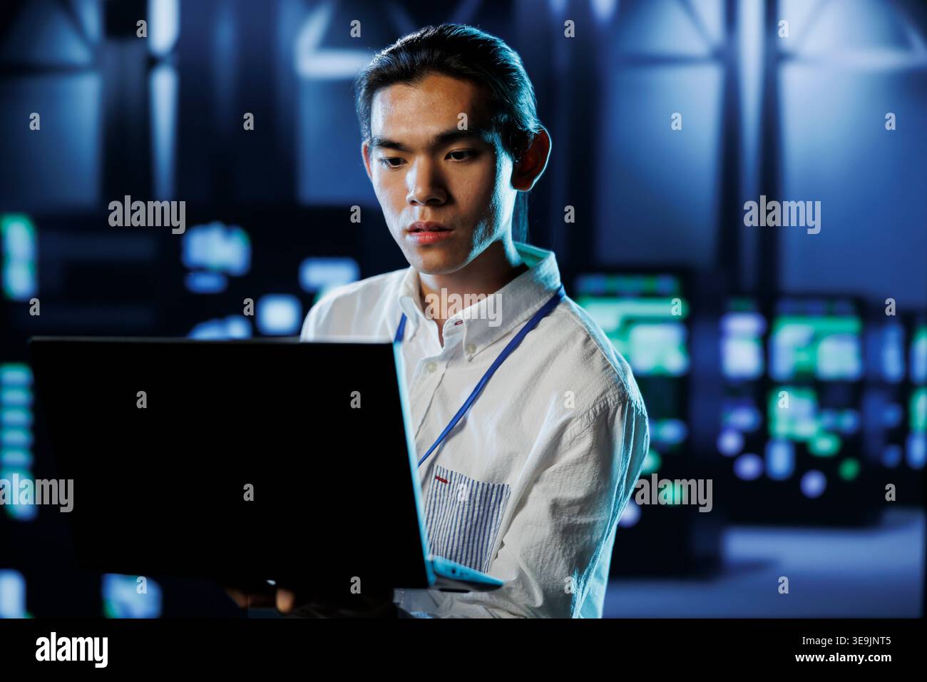 Qualified engineer between server hub rows providing processing resources for businesses worldwide. Certified expert fixing data center mainframes tasked with managing massive databases Stock Photo