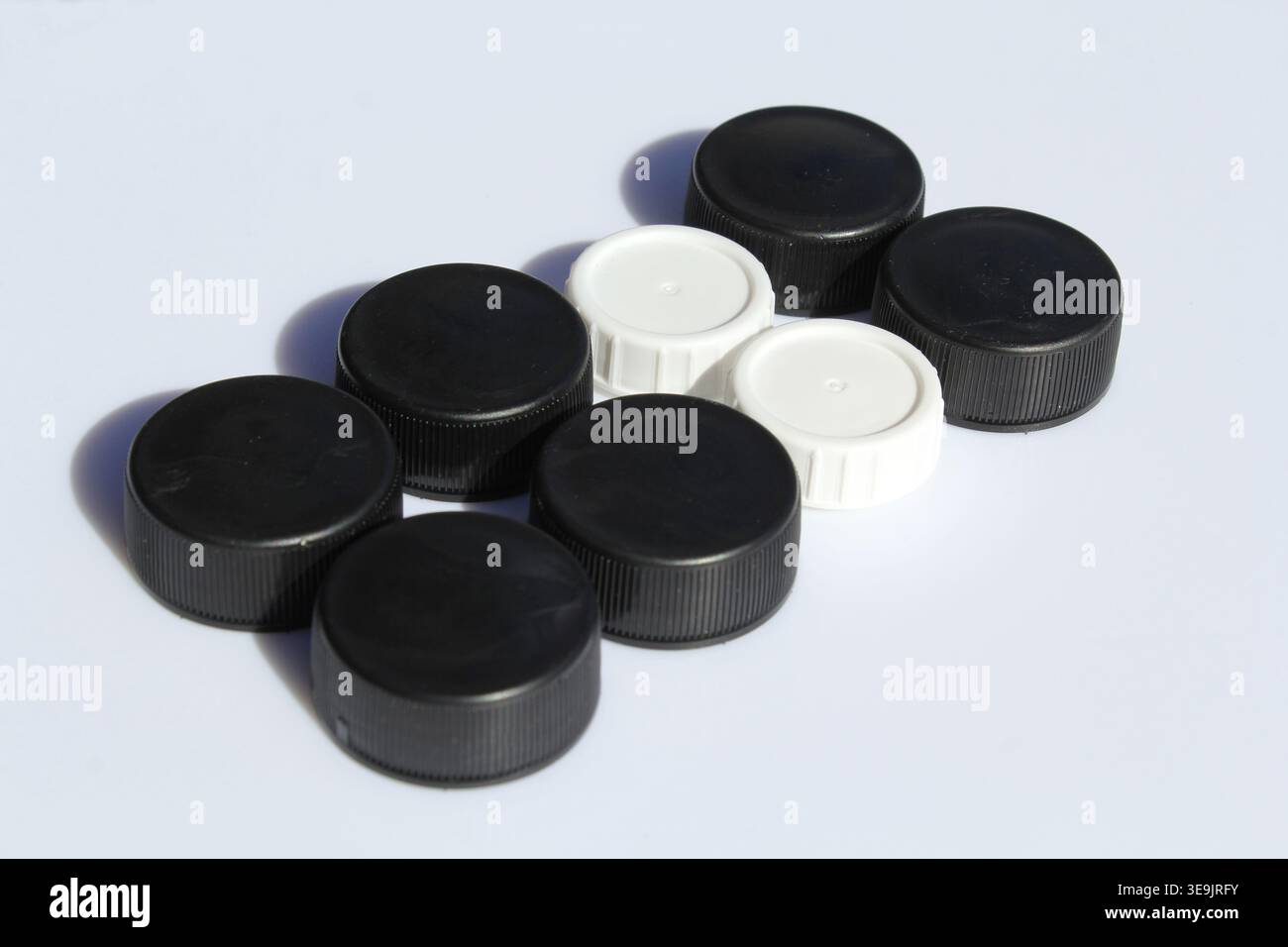 Black and white plastic bottle caps on a white background Stock Photo