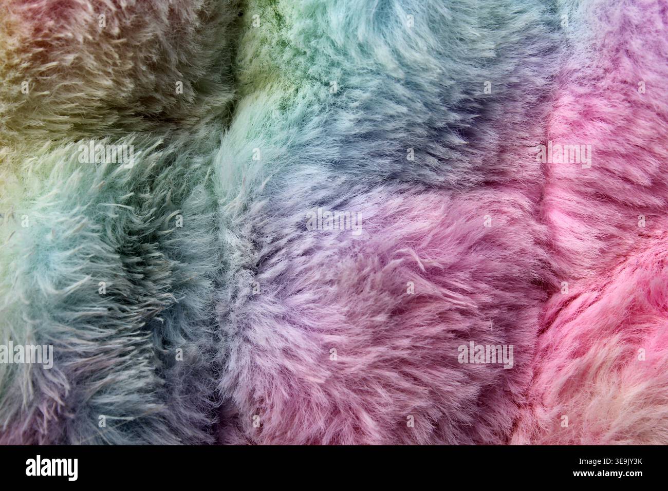 Macro full-frame background of soft, fluffy rainbow faux fur fabric featuring vibrant pastel colours Stock Photo