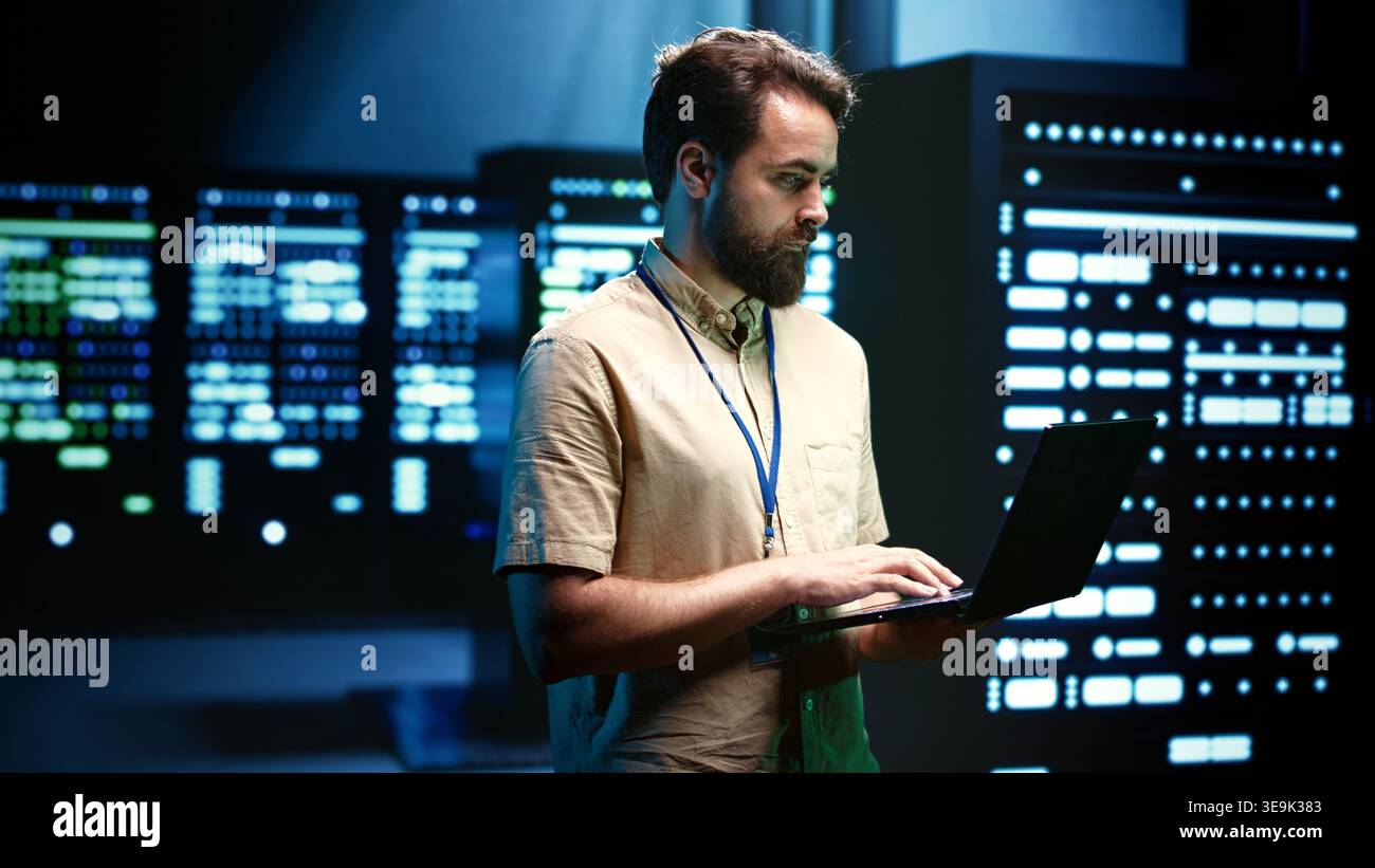 Precise serviceman verifying functional blade servers in computer network security data center. High tech facility infrastructure providing processing and memory resources for numerous workloads Stock Photo