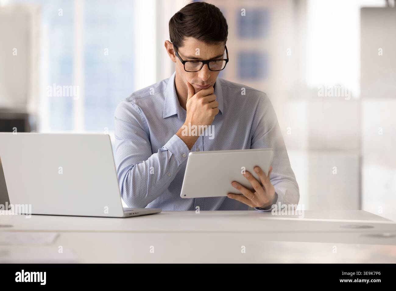 Focused man analyzing data on digital tablet Stock Photo