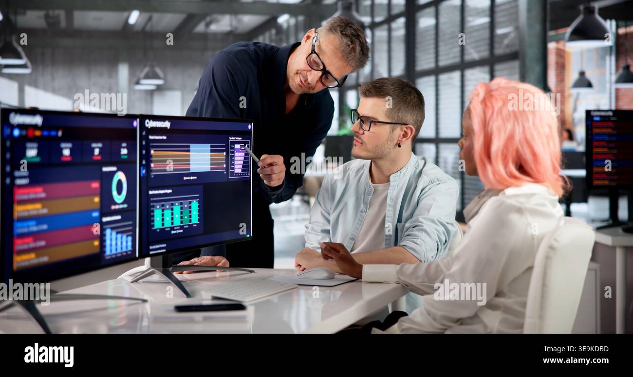 Cybersecurity Engineer Carefully Monitors Threats With Team Using Advanced Data Tools. Stock Photo