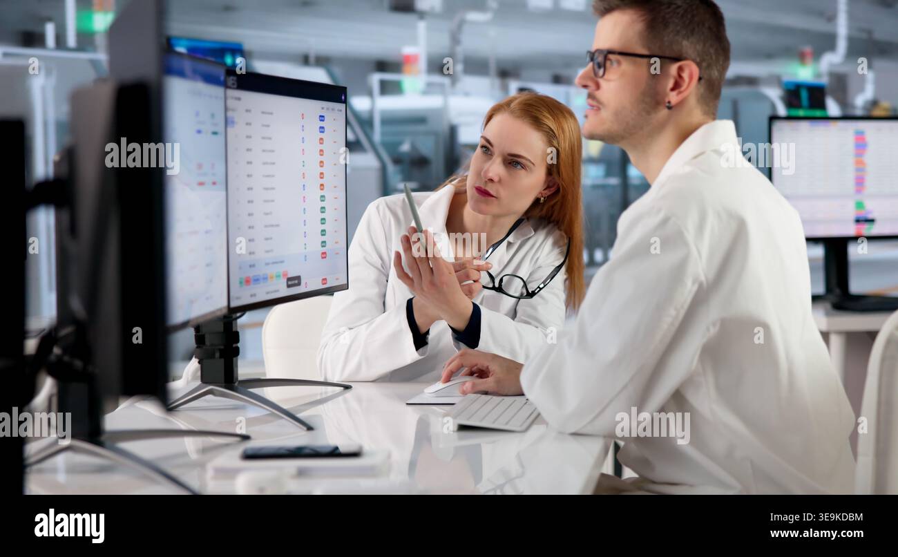 Factory Manager Monitors Real-time Production Data On Desktop Computer. Stock Photo
