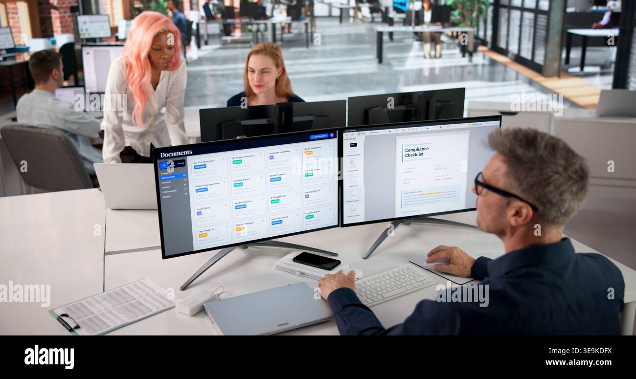 Project Manager Reviewing Workflow Documents On Computer For Team Collaboration. Stock Photo