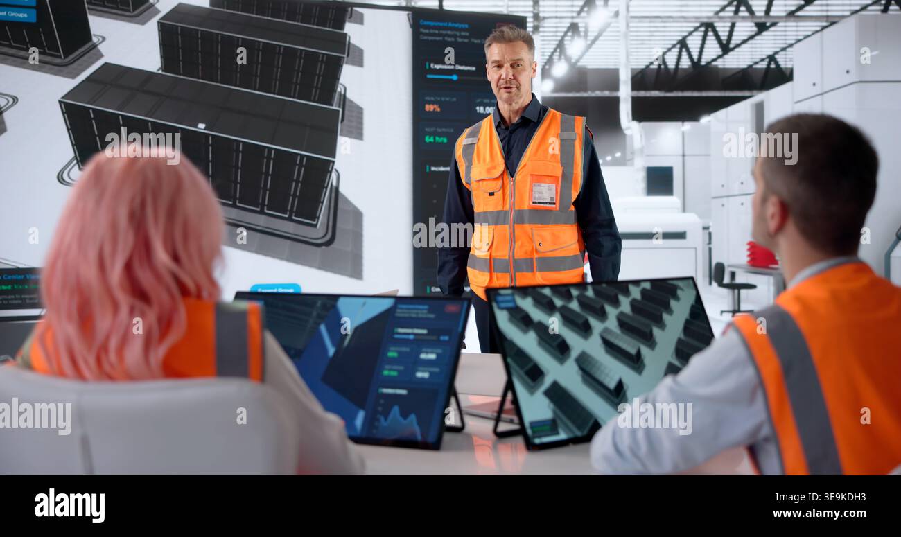 Engineer Leads Team Meeting, Explaining Data Center Infrastructure Build Plan. Stock Photo