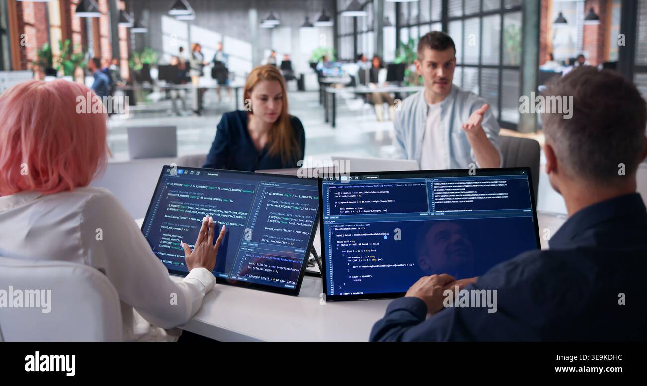 Software Engineers Collaborating Closely On Secure Code Review During Team Meeting. Stock Photo
