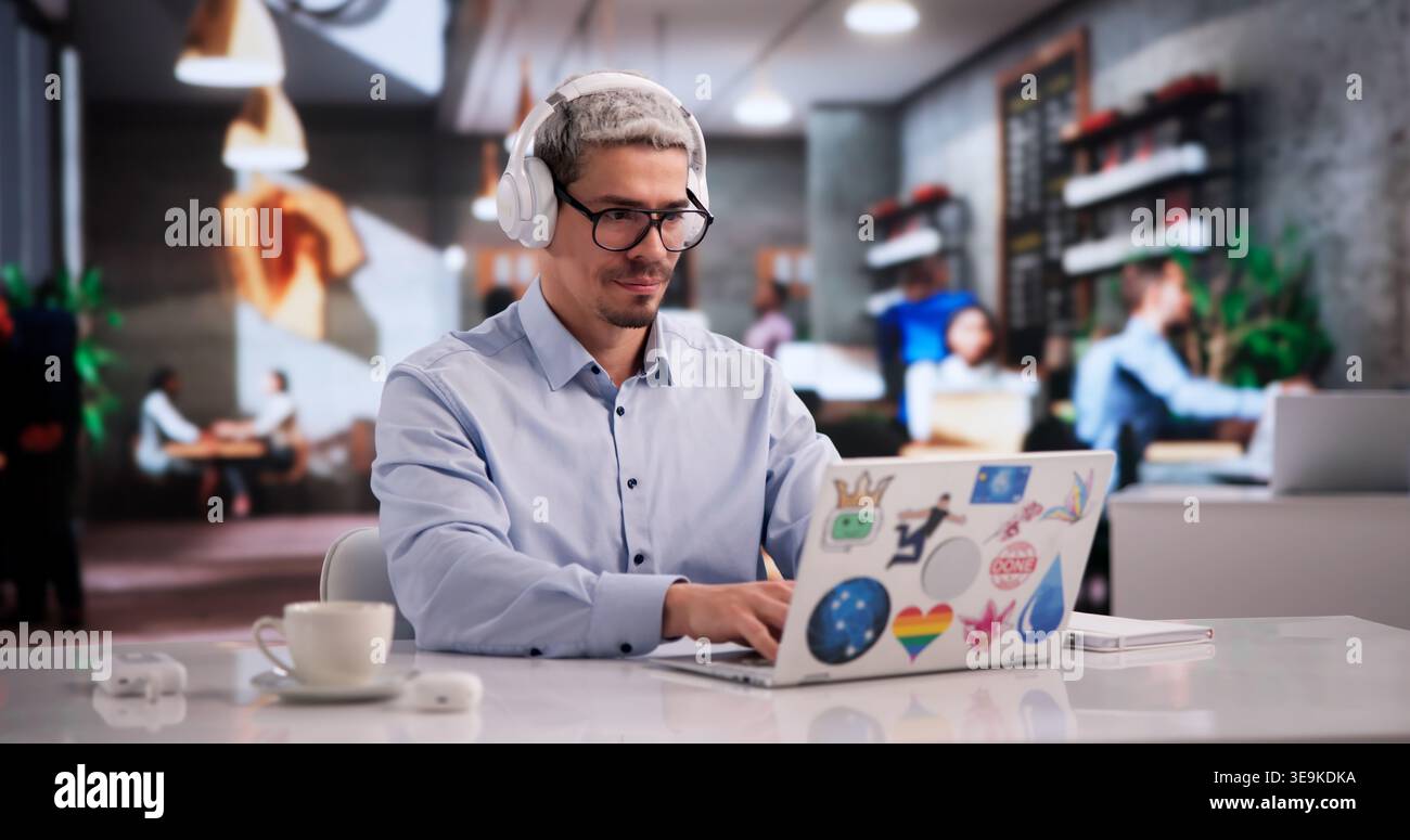 Focused Graphic Design Learner Using Laptop In Lively Coffee Shop Setting Stock Photo