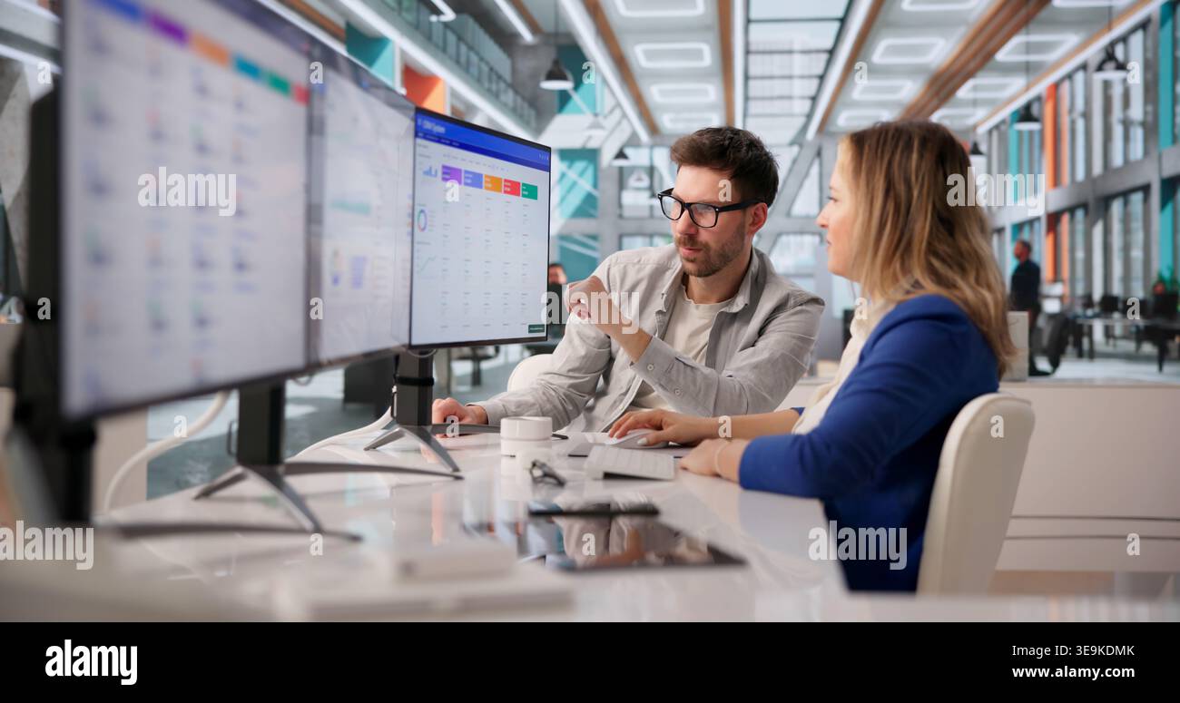Two Software Developers Collaborate On CRM Functionality In Corporate Meeting Stock Photo