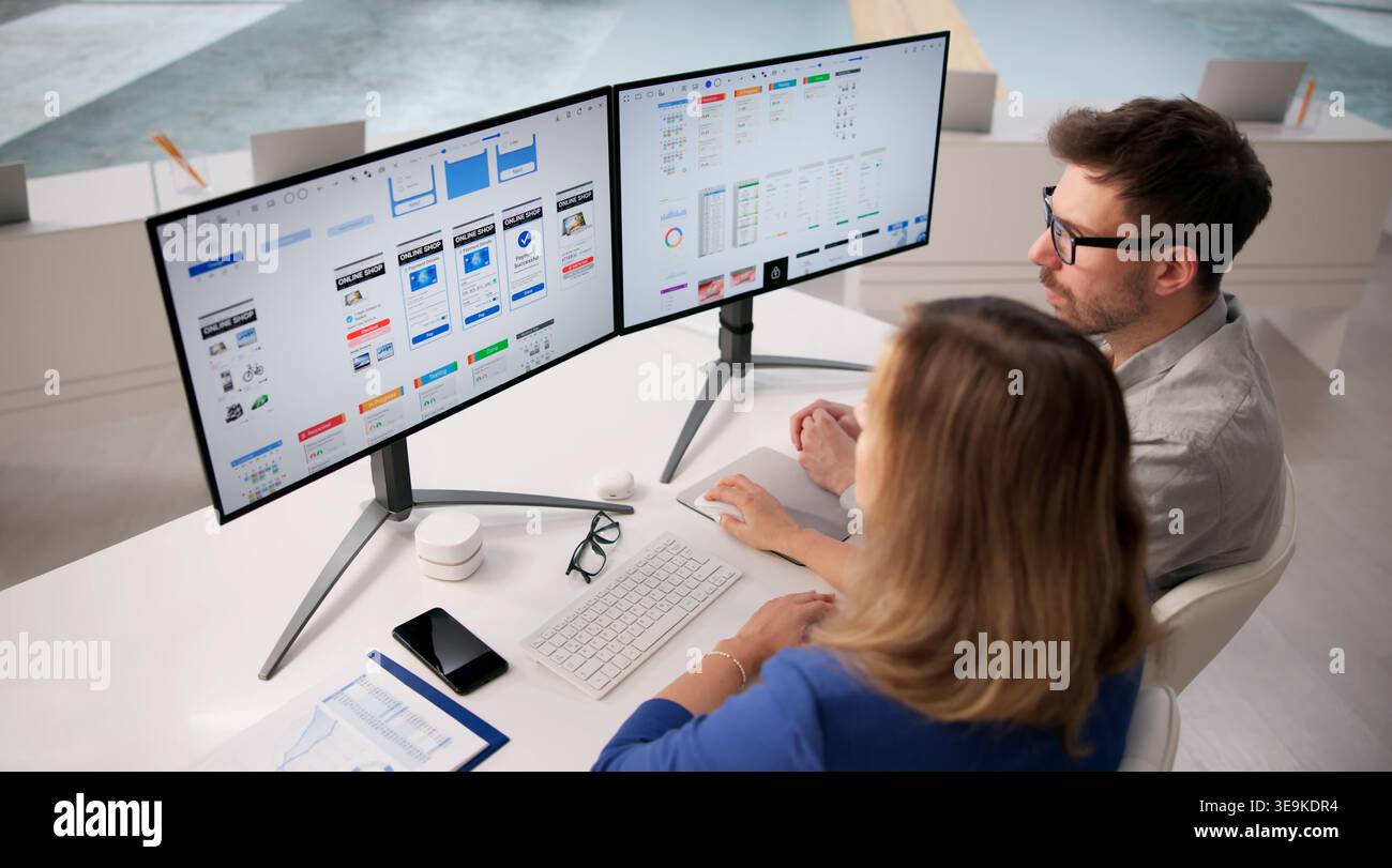 Creative Team Collaborating On User Interface Design At Workspace Using Computers Stock Photo