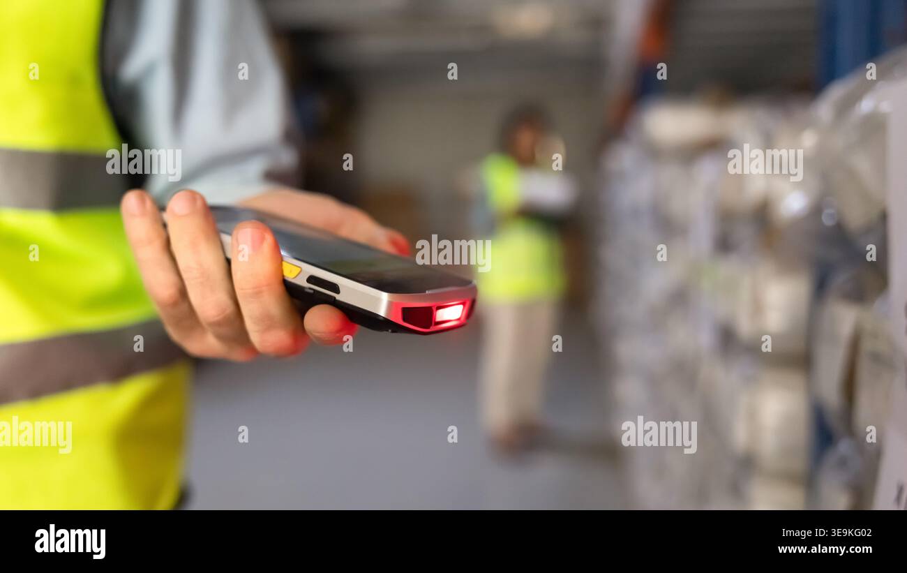 Worker using handheld barcode scanner in industrial warehouse facility, closeup Stock Photo