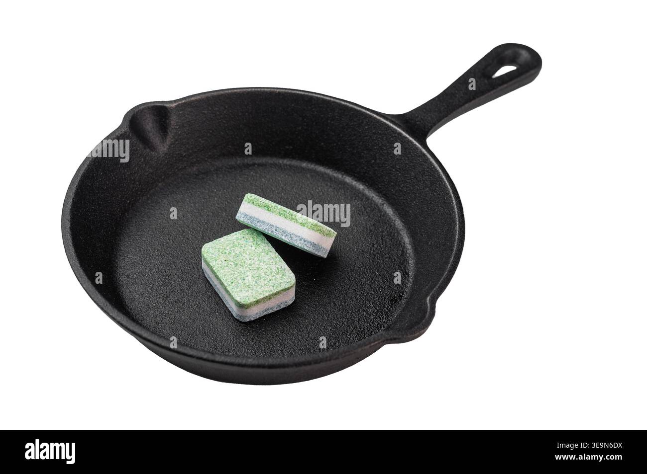 Dishwasher detergent tablets inside cast iron pan on dark background creative metaphor of cleaning versus cooking concept. Stock Photo