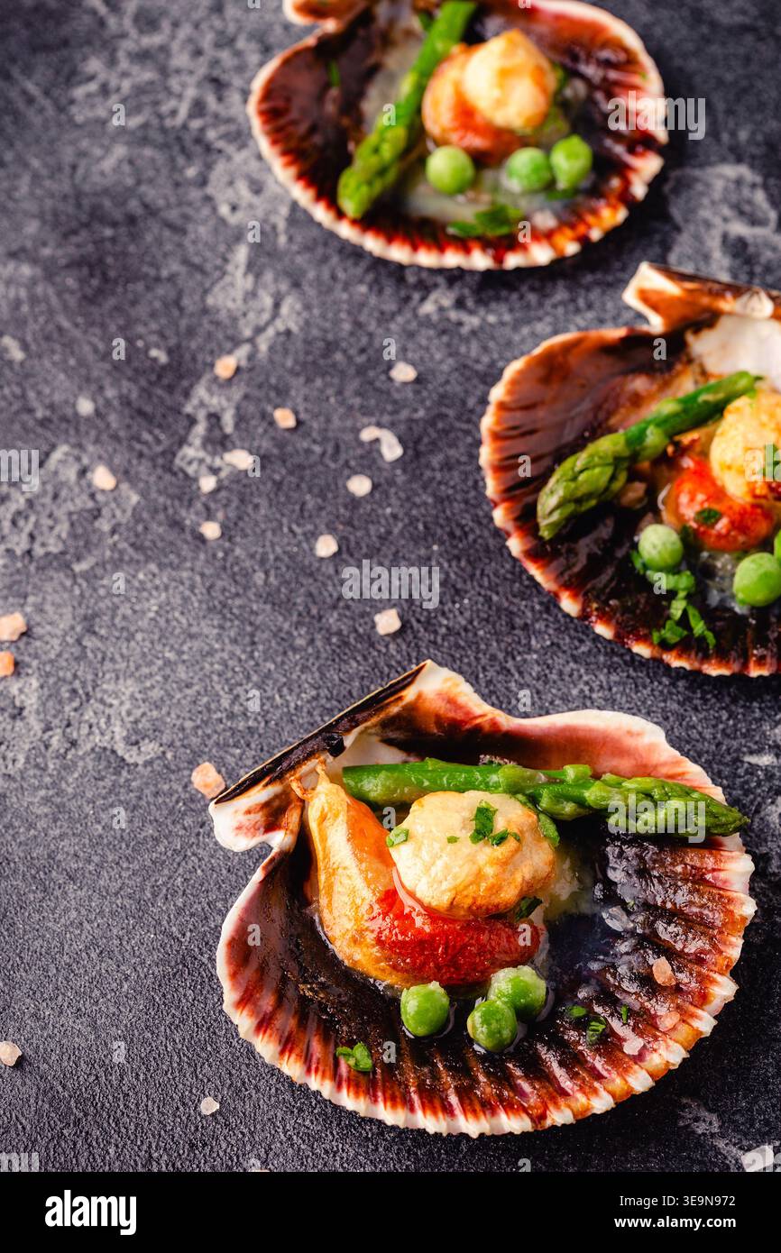 Cooked scallops with vegetables on a dark background Stock Photo