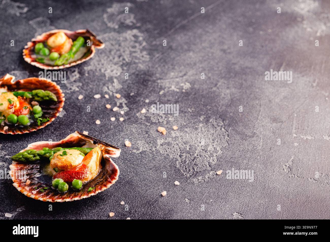Cooked scallops with vegetables on a dark background Stock Photo