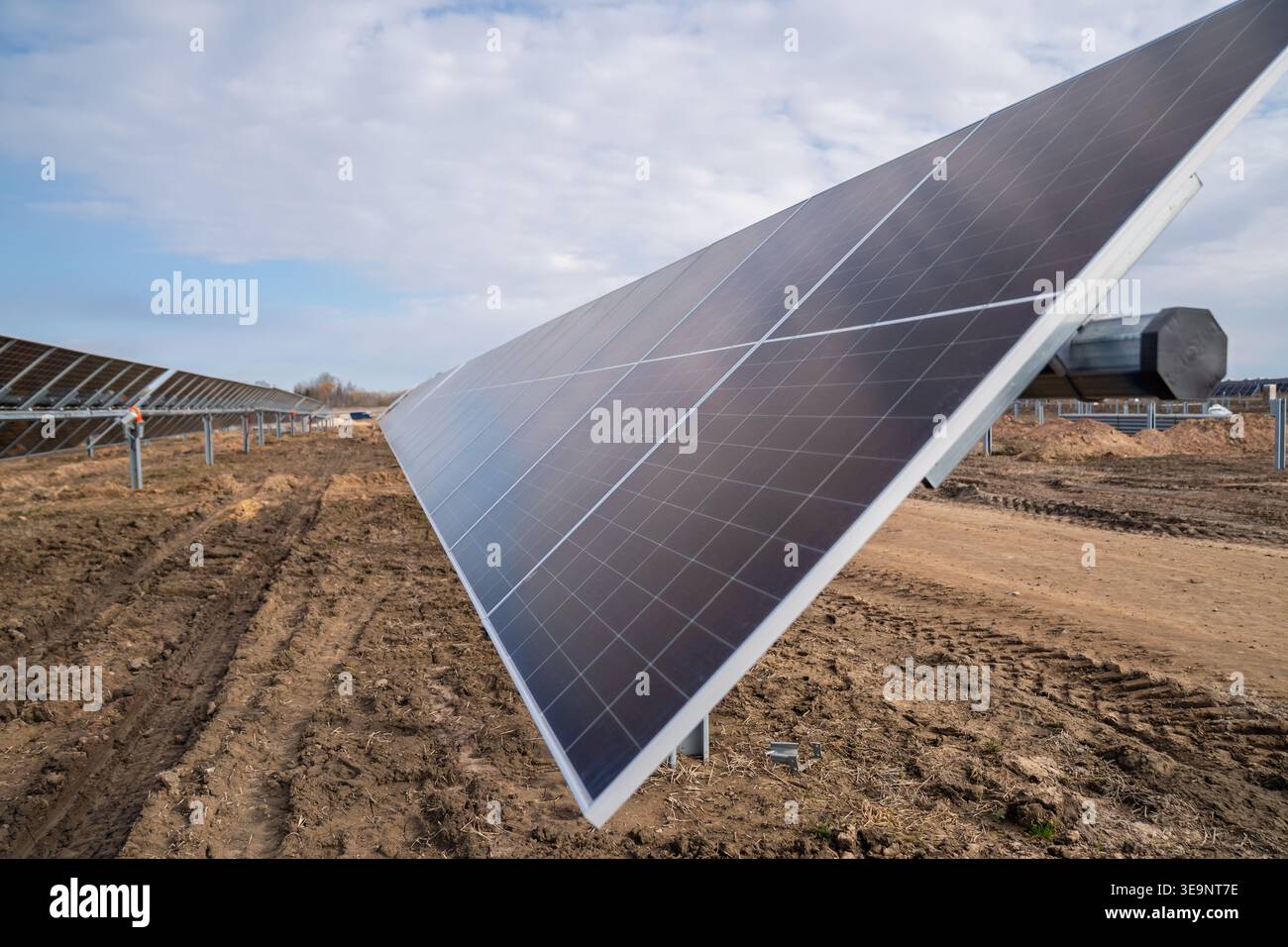 Utility scale solar array with tilted panel edge, muddy tire tracks ...